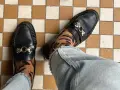 Elegantes mocasines negros con detalle de tigre en los calcetines, un ejemplo de los diversos tipos de mocasines.