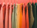 Percheros con ropa de tonos cálidos y fríos, un arcoíris de color verano listo para usar.