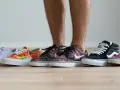 Un hombre elige entre varias zapatillas de **material canvas**. Hay modelos de colores, estampados florales, de cuadros y lisos.