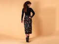 Mujer con falda lápiz negra estampada con flores de colores. Un ejemplo de los diversos tipos de faldas.