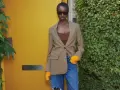 Mujer con blazer de cuadros, top marrón y vaqueros rotos. Ideas de qué ponerse debajo de una blazer para un look moderno.