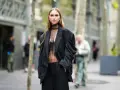 Mujer con traje negro y top transparente, ideal para saber como ir vestida a un cóctel de tarde.