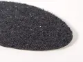 Textura granulada de una suela de caucho resbala, con pequeños brillos que capturan la luz.