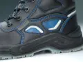Bota de trabajo negra con costuras azules y detalles en azul y blanco. La suela tpu ofrece agarre y durabilidad para cualquier terreno.