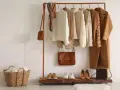 Un armario cápsula mujer con prendas de punto, abrigos y bolsos en tonos tierra. Perfecto para un estilo minimalista y chic.