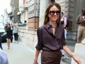 Mujer con camisa marrón y pantalones a juego, combinando estilo y elegancia en la calle.