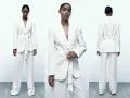 Mujer posa con un elegante traje blanco de pantalón y blazer con cinturón. Un look sofisticado para combinar traje blanco mujer.