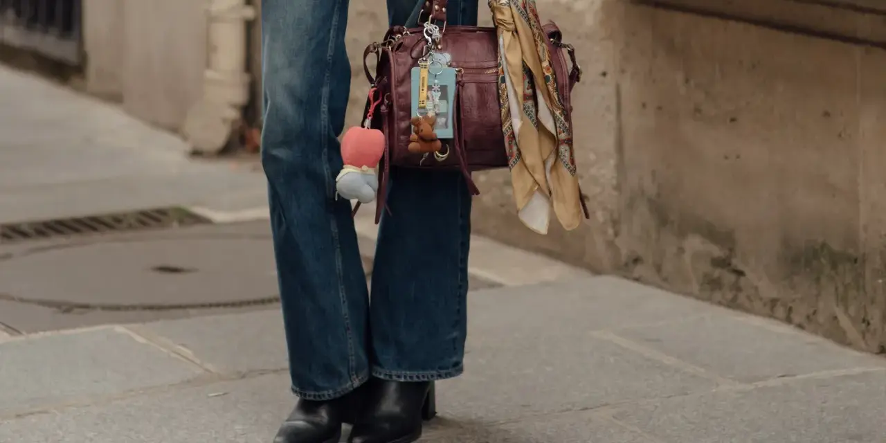 Botas negras elegantes con tacón, perfectas para complementar unos pantalones vaqueros anchos y un bolso de cuero con adornos.