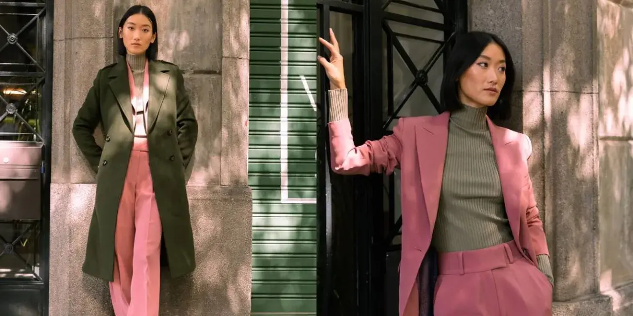 Mujer posa con un traje rosa y un abrigo verde. Inspírate para combinar traje verde mujer con estilo.