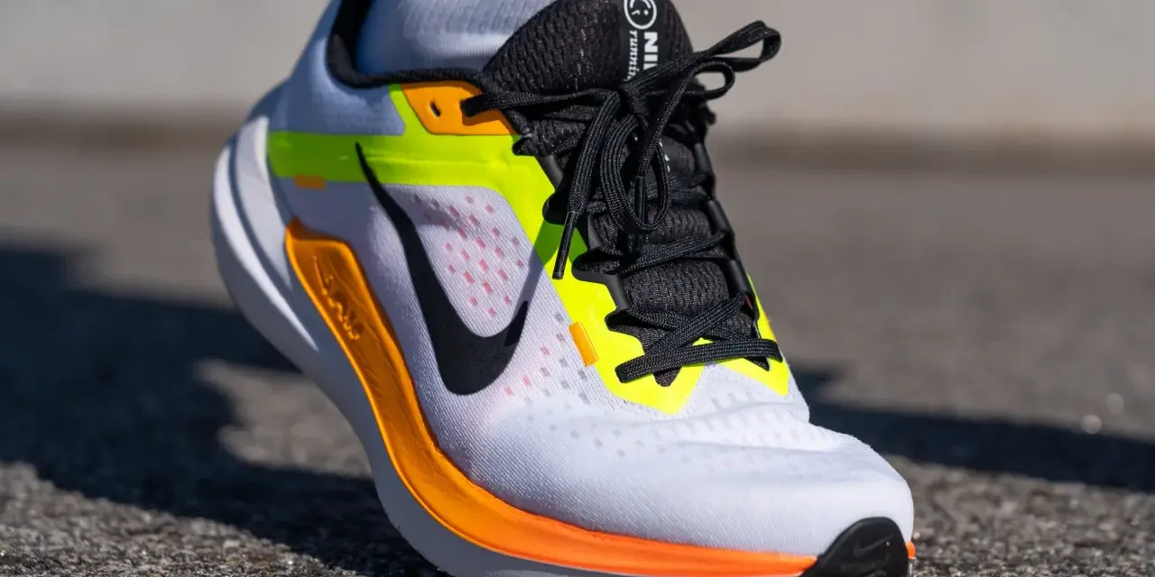 Zapatillas Nike Winflo 10 blancas con detalles en naranja y neón, listas para correr.