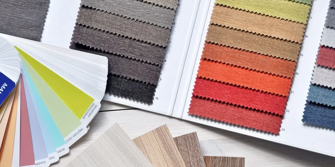 Muestras de telas y laminados en tonos tierra y vibrantes, evocando una **primavera brillante**.
