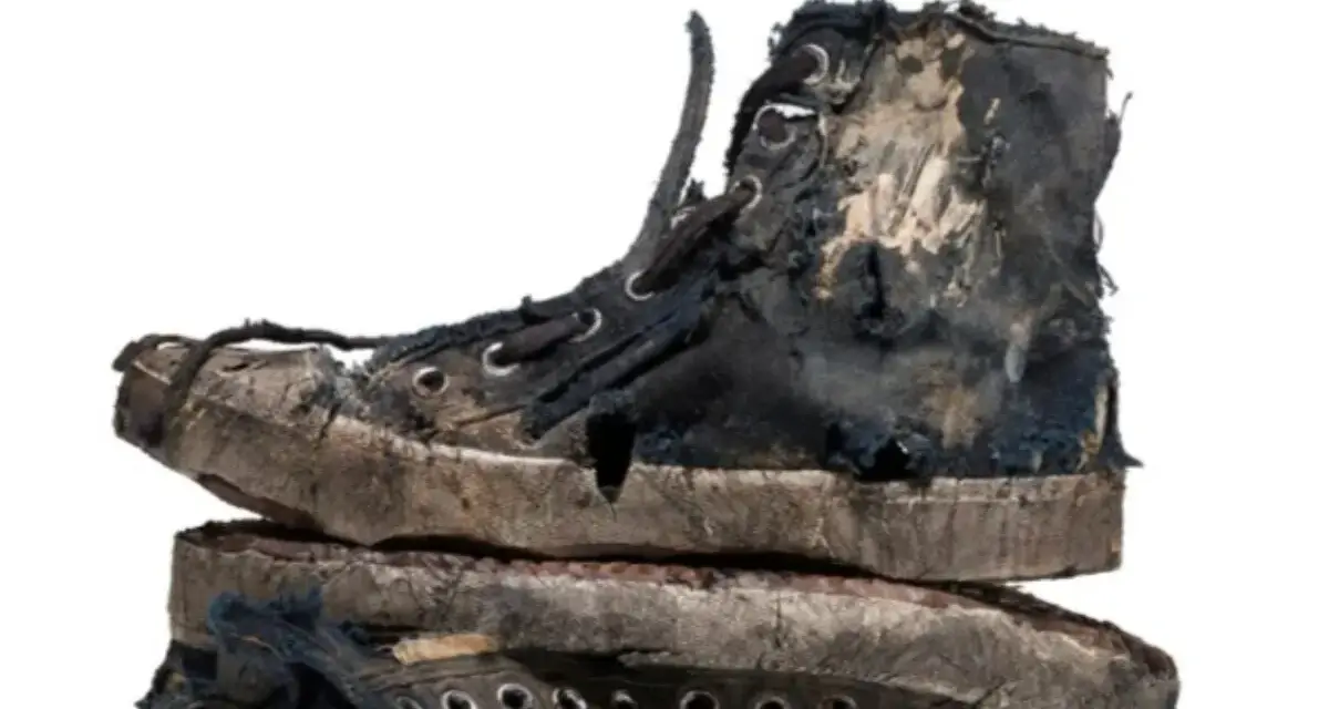 Un par de zapatillas gastadas, rotas y sucias, apiladas una sobre otra. Parecen haber vivido muchas aventuras.