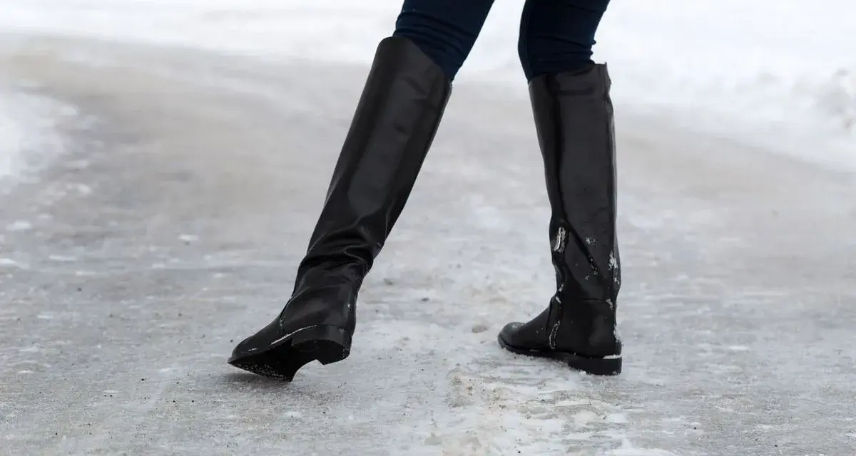 Botas negras sobre hielo. ¿Qué hacer para que no resbalen los zapatos? Evita caídas con buen calzado.