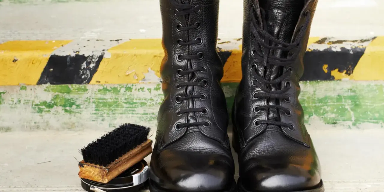 Botas militares negras, cepillo y betún. Aprende como limpiar botas militares para que luzcan impecables.