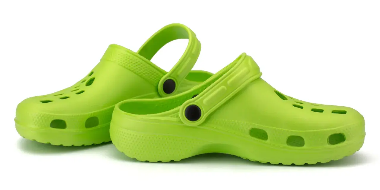 Zapatos verdes tipo crocs, ideales para aliviar la fascitis plantar.