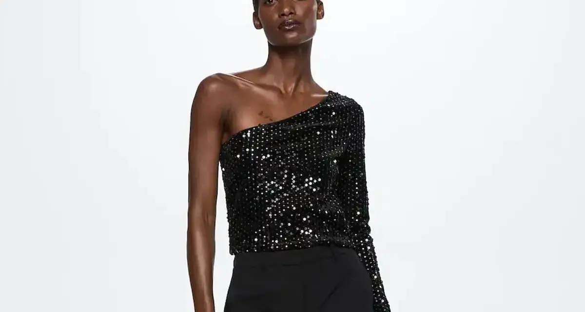 Top negro de lentejuelas asimétrico, ideal para saber como vestir para un cumpleaños de noche mujer.