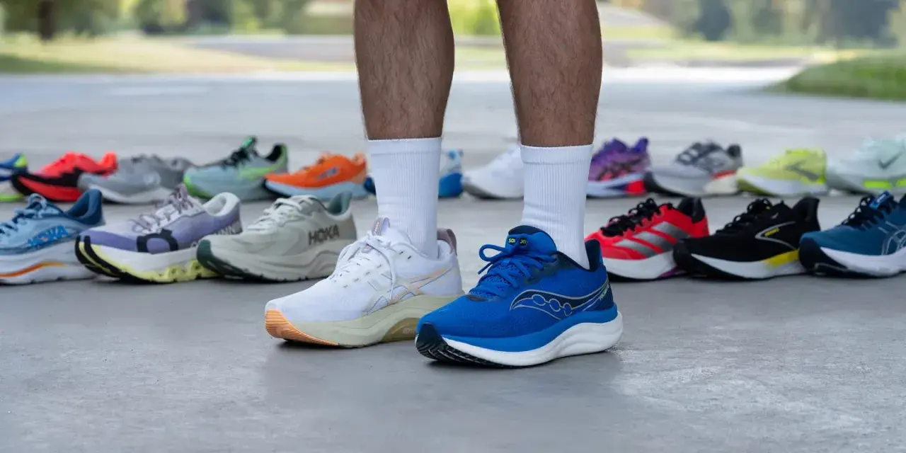 Un corredor muestra varias zapatillas deportivas, buscando el mejor calzado para tendinitis aquiles.