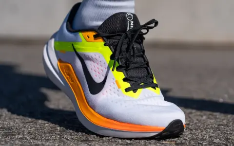 Zapatillas Nike Winflo 10 blancas con detalles en naranja y neón, listas para correr.