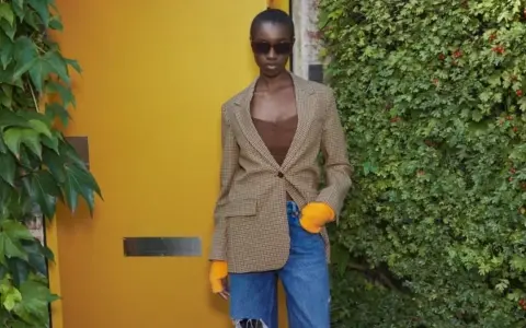 Mujer con blazer de cuadros, top marrón y vaqueros rotos. Ideas de qué ponerse debajo de una blazer para un look moderno.