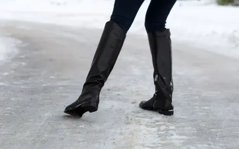 Botas negras sobre hielo. ¿Qué hacer para que no resbalen los zapatos? Evita caídas con buen calzado.