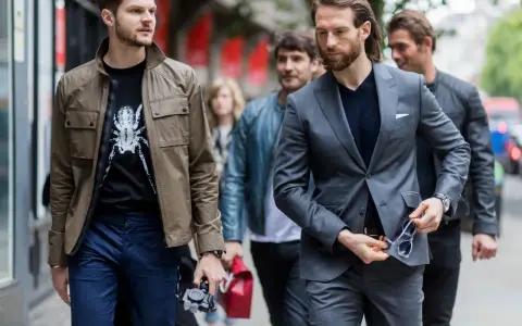 Hombres con estilo, uno con chaqueta y camiseta estampada, otro con traje gris. Dress code casual.