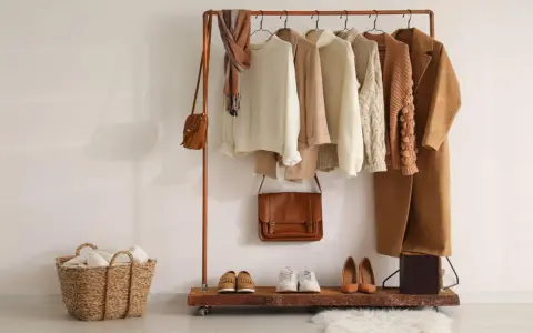 Un armario cápsula mujer con prendas de punto, abrigos y bolsos en tonos tierra. Perfecto para un estilo minimalista y chic.