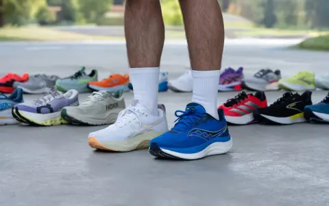Un corredor muestra varias zapatillas deportivas, buscando el mejor calzado para tendinitis aquiles.