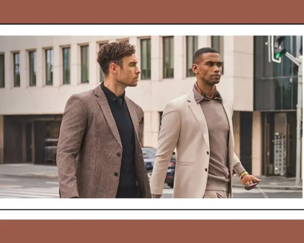 Dos hombres con trajes elegantes caminan por la calle. Uno lleva un traje beige y el otro un traje marrón.