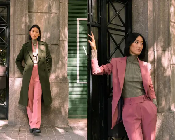 Mujer posa con un traje rosa y un abrigo verde. Inspírate para combinar traje verde mujer con estilo.