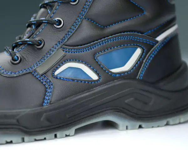 Bota de trabajo negra con costuras azules y detalles en azul y blanco. La suela tpu ofrece agarre y durabilidad para cualquier terreno.