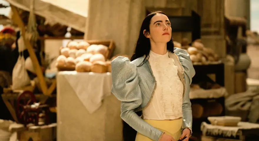Mujer con estilo coquette aesthetic, con chaqueta celeste de volantes y blusa blanca, en un mercado con pan.