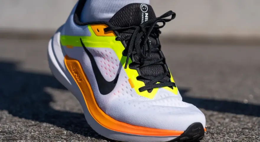Zapatillas Nike Winflo 10 blancas con detalles en naranja y neón, listas para correr.