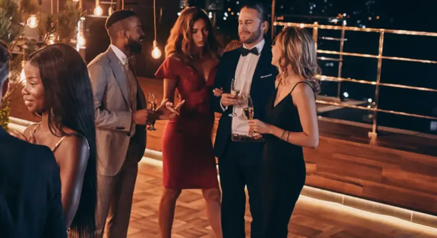 Elegante fiesta en España, cumpliendo el dress code cocktail. Hombres con traje y pajarita, mujeres con vestidos de cóctel.