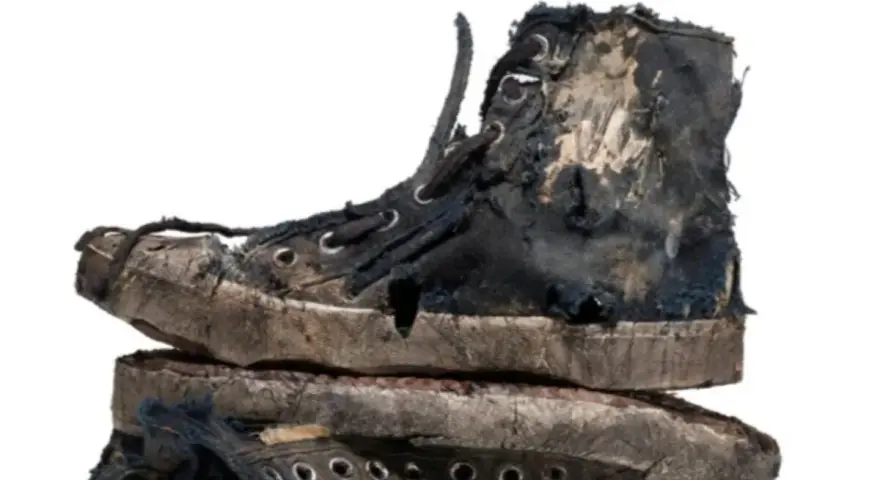 Un par de zapatillas gastadas, rotas y sucias, apiladas una sobre otra. Parecen haber vivido muchas aventuras.