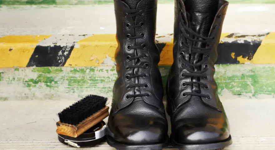 Botas militares negras, cepillo y betún. Aprende como limpiar botas militares para que luzcan impecables.