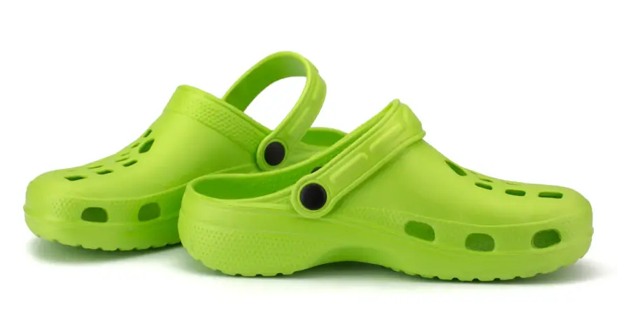 Zapatos verdes tipo crocs, ideales para aliviar la fascitis plantar.