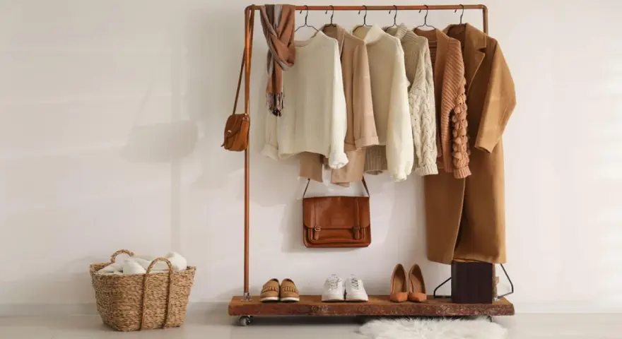 Un armario cápsula mujer con prendas de punto, abrigos y bolsos en tonos tierra. Perfecto para un estilo minimalista y chic.