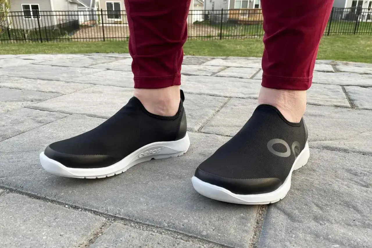 Zapatos negros cómodos con suela blanca, ideales para caminar y aliviar la fascitis plantar.