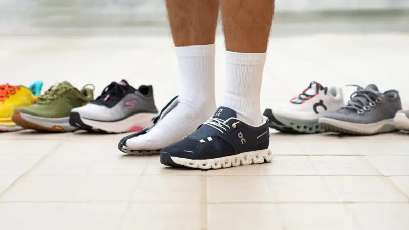 Un hombre prueba varios modelos de zapatillas, buscando el mejor calzado para caminar.